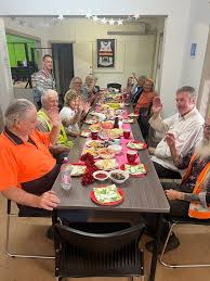 Community members sharing a meal together at a long table